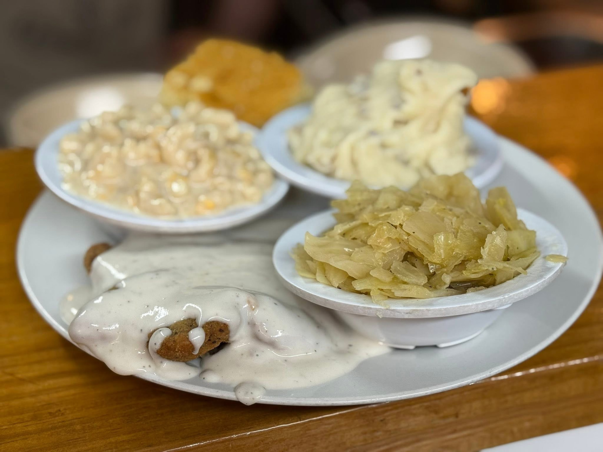 Country fried steak smothered in white gravy with Southern sides